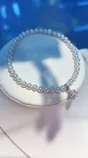 A white pearl bracelet paired with a silver diamond-encrusted spherical pendant and glass titanium steel crystal jewelry details Picture